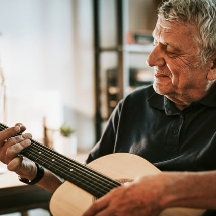 A happy man playing a guitar.