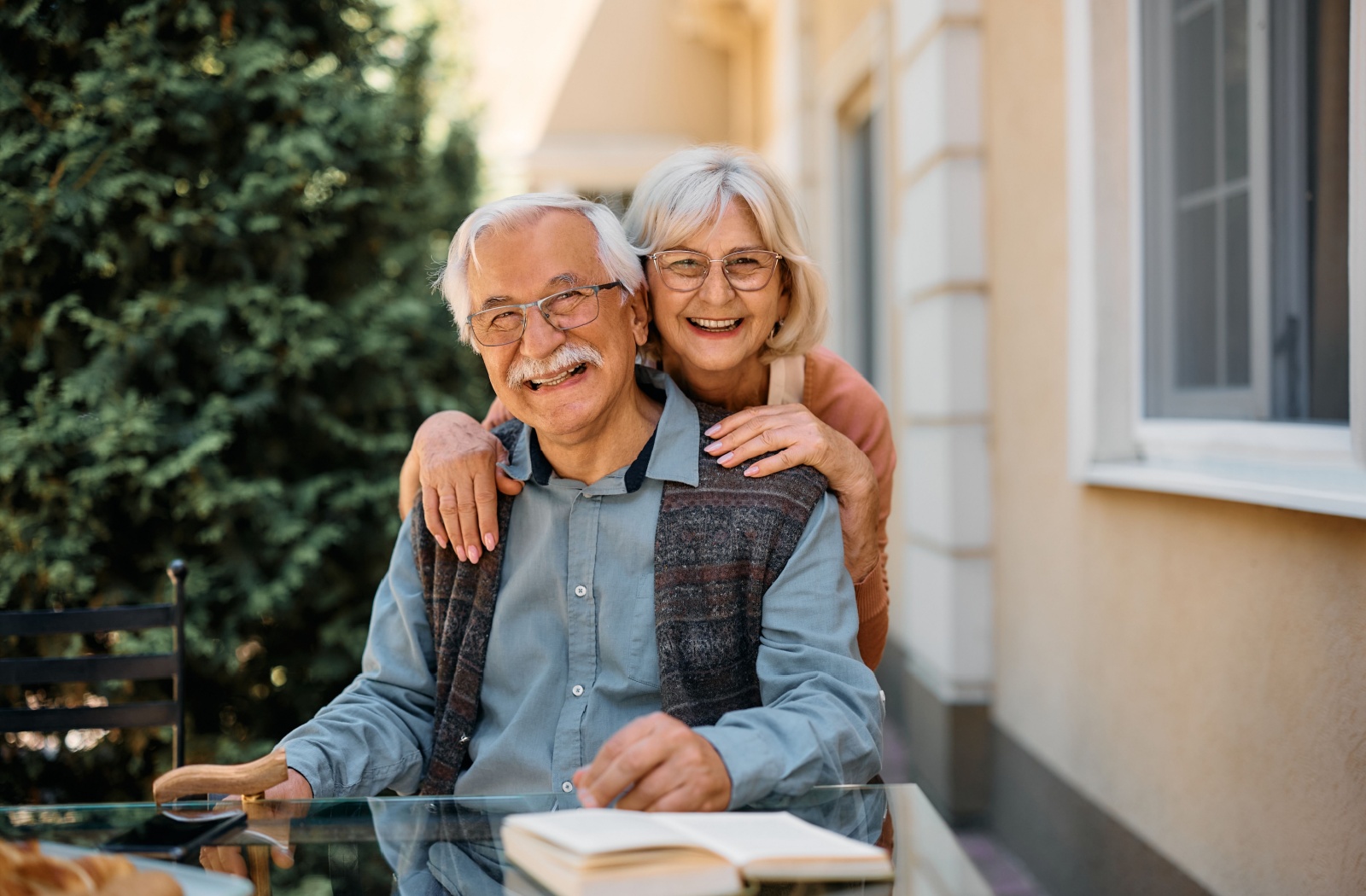 A happy senior couple enjoy time outside their independent living home.